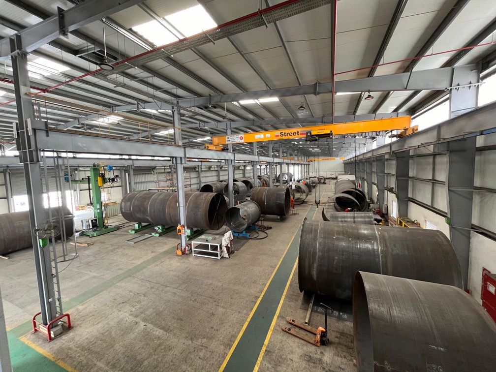 Carbon steel fabrication shed with large shell sections and overhead crane
