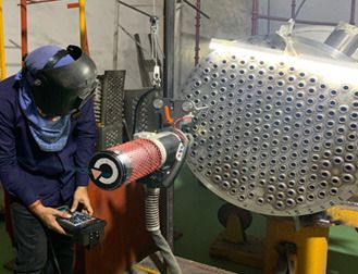 Welder operating an automated tube welding station